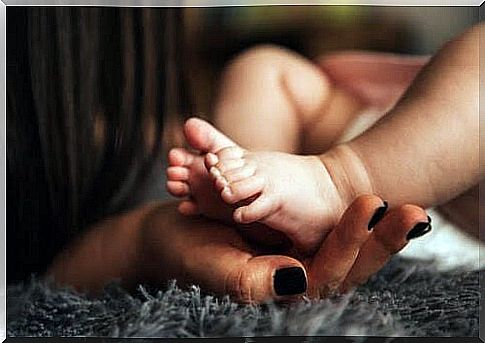 hand holding feet of newborn