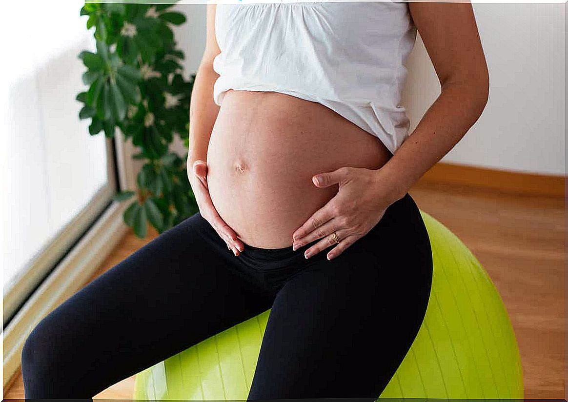 A pregnant woman on a yoga ball.