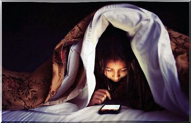 children with mobile phone under cover