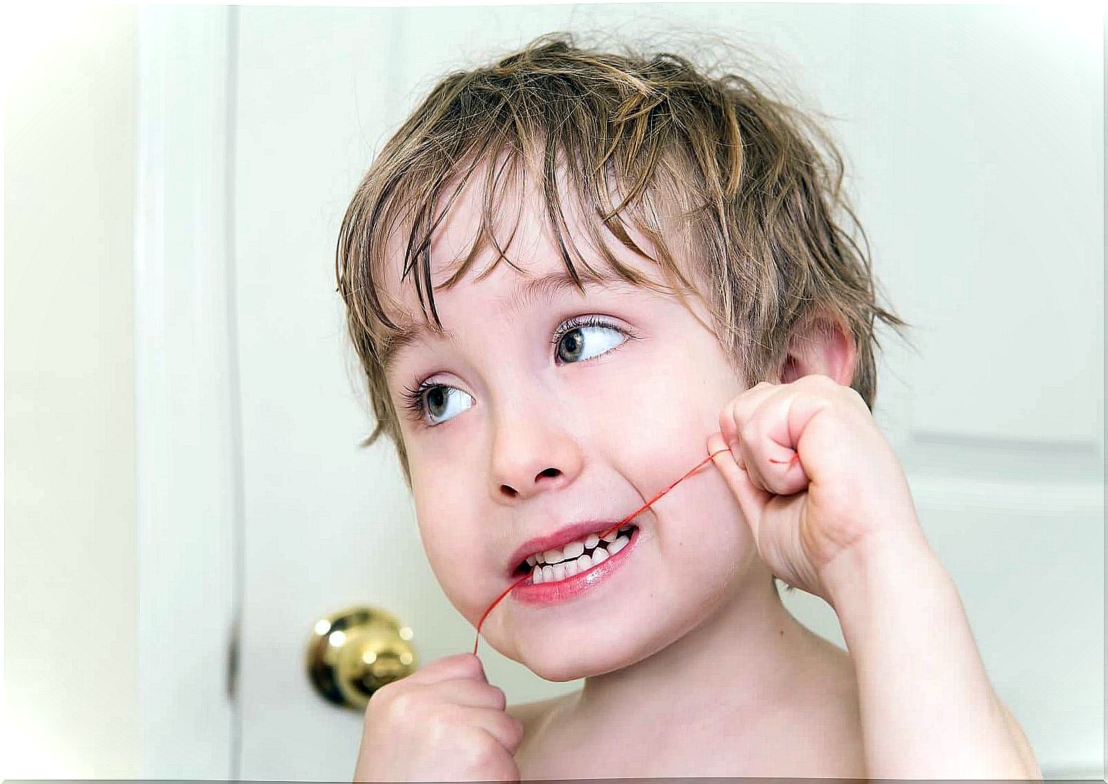 A young boy flossing.