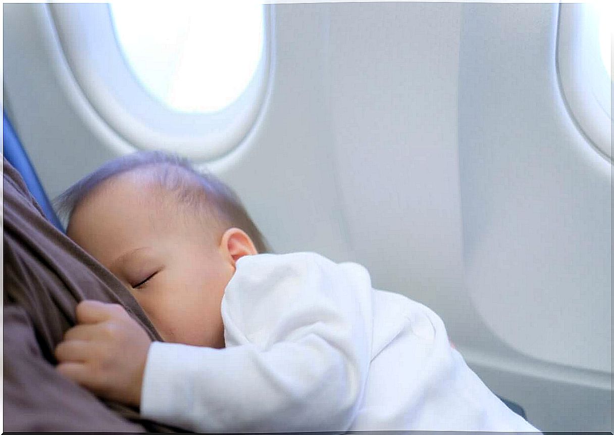 A baby sleeping on a plane.