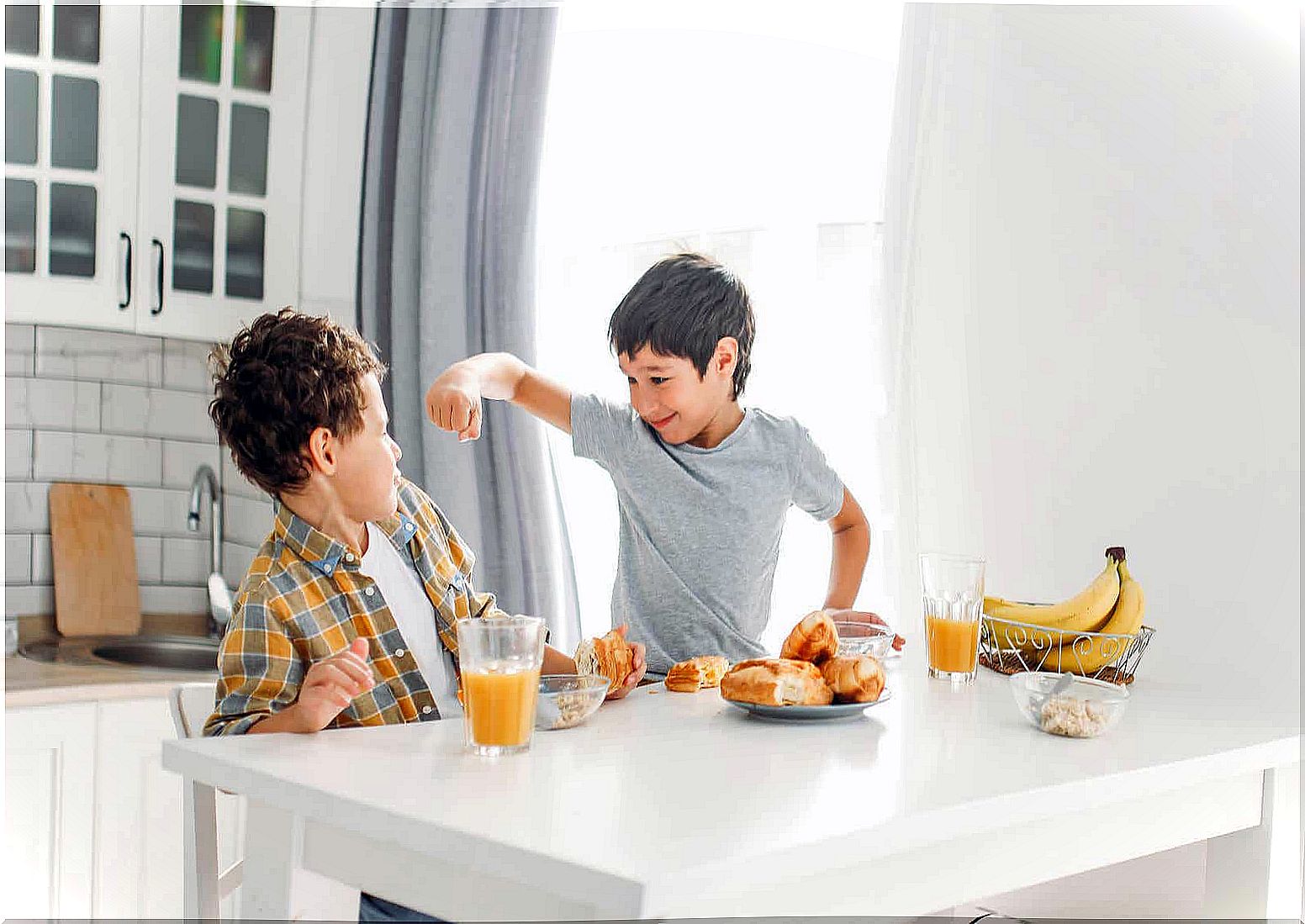 Two brothers fighting at the table.