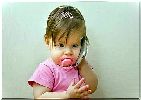 baby with phone and pacifier