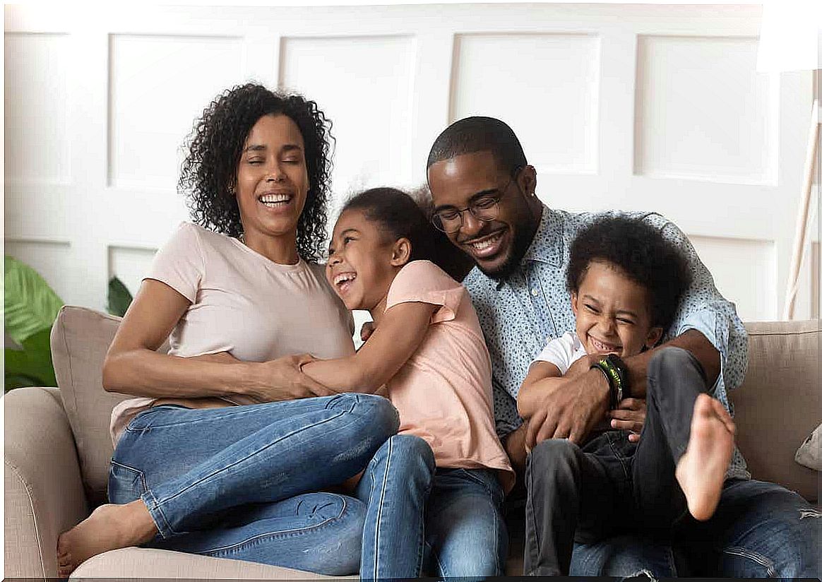 A family laughing together on the couch.