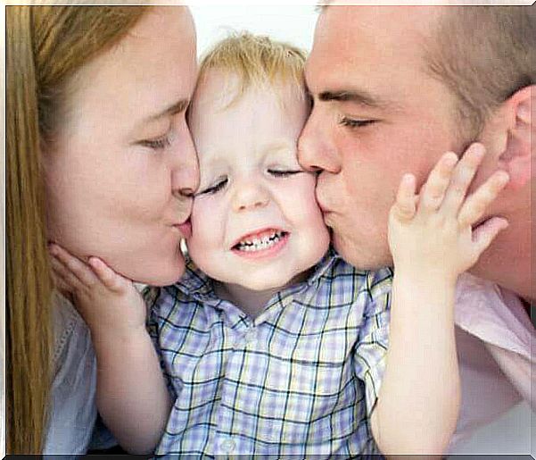 mom and dad kiss children on each cheek