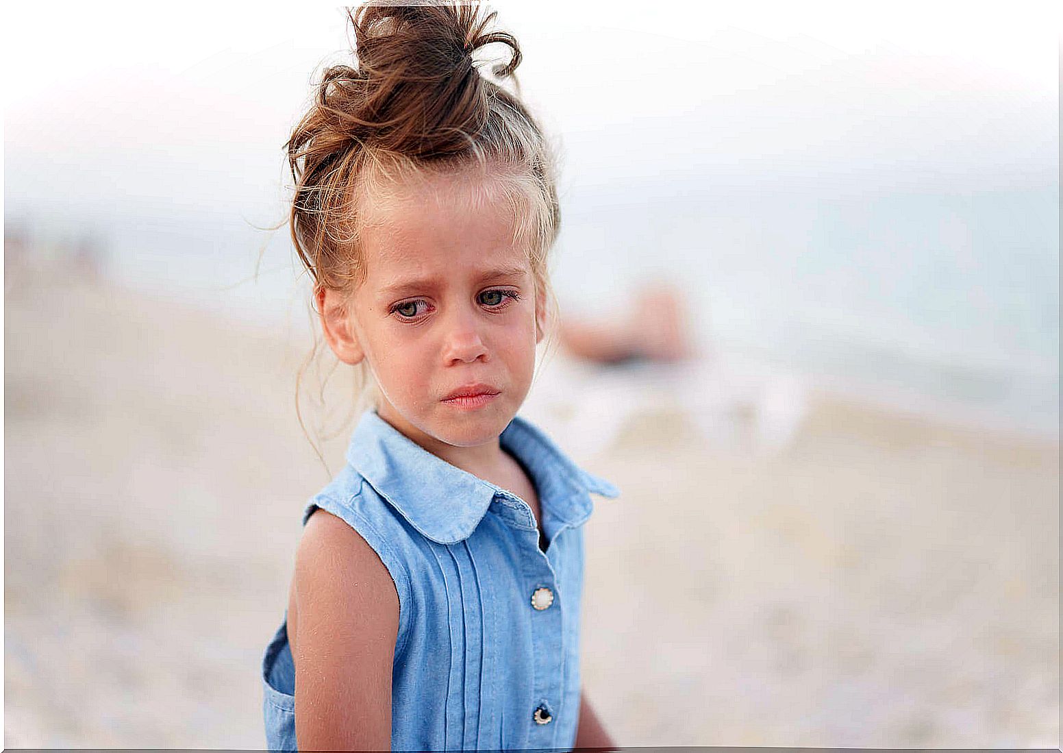 a child is sad on the beach