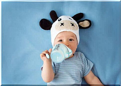 visit with your baby: baby in a cute hat and with a baby bottle