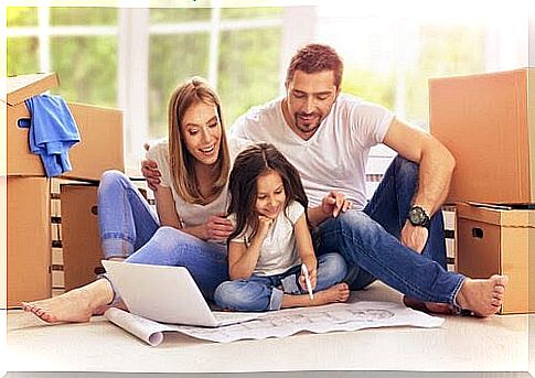 Woman and man sitting on the floor and watching girl writing