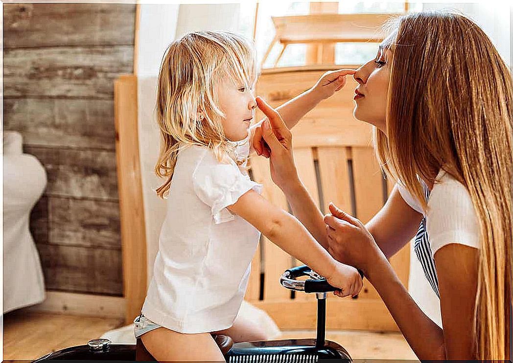 A mother and her children touch each other's noses.