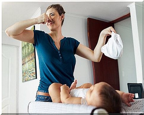 A mother changes a dirty diaper on the baby.