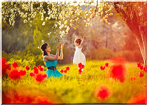 positive parenting: mother and child playing in meadow