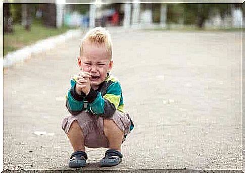 Children sit on the street and cry.