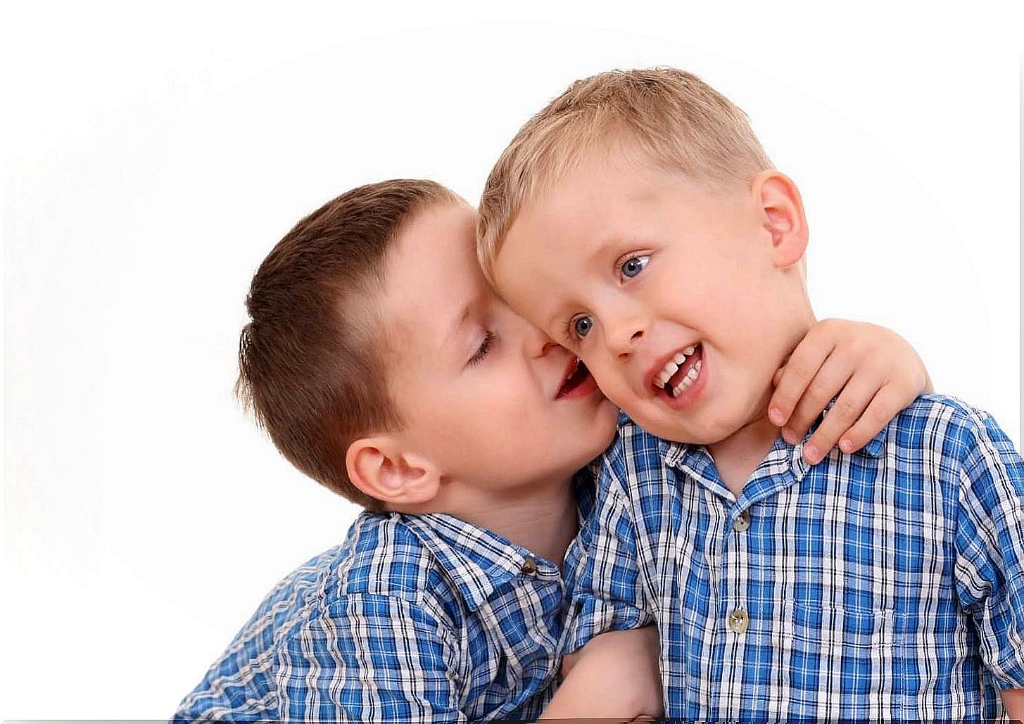 children whisper in another child's ear