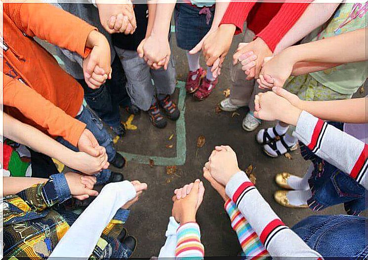 Children holding hands in ring.