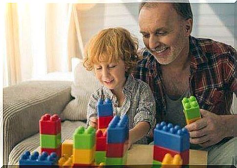 Father and child build with big Lego together.