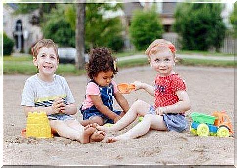 Children practice their social skills through games in the sandbox.