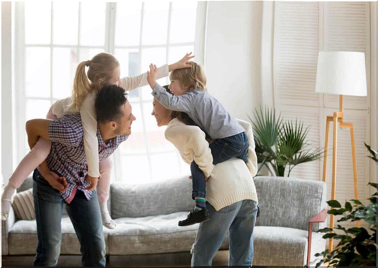 Parents playing with their children in their living room.