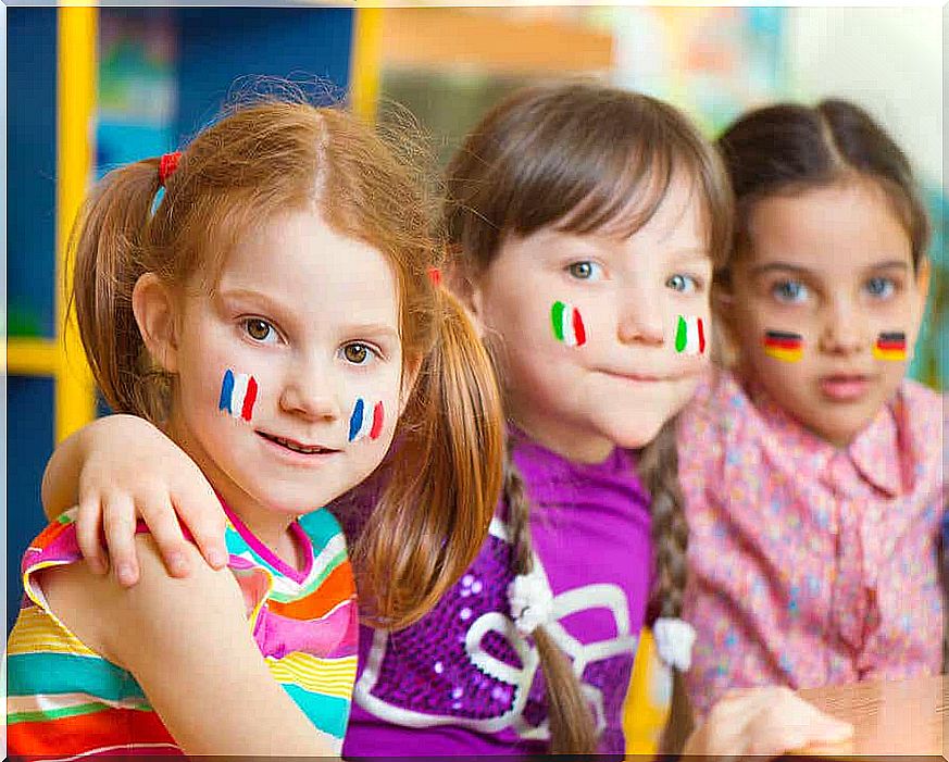 Three little girls with different flags painted on their cheeks.