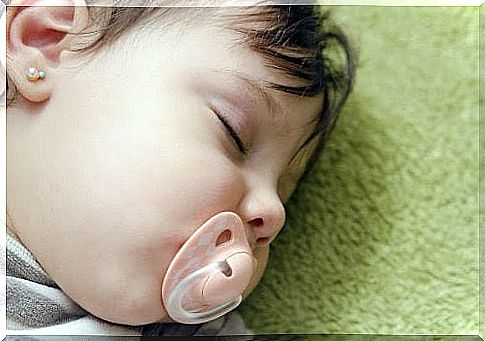 Baby sleeps with a pacifier in his mouth