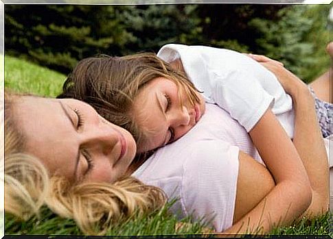 Mother and daughter lying on the grass.