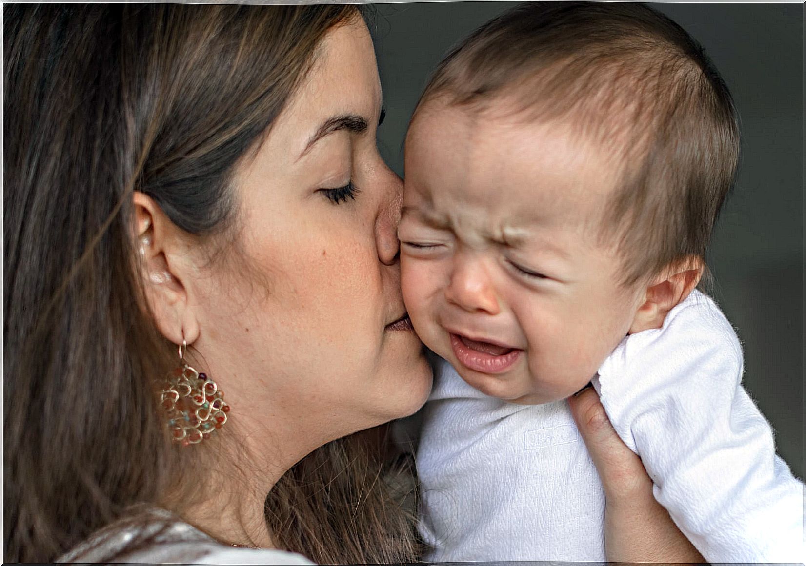 Mom kisses baby